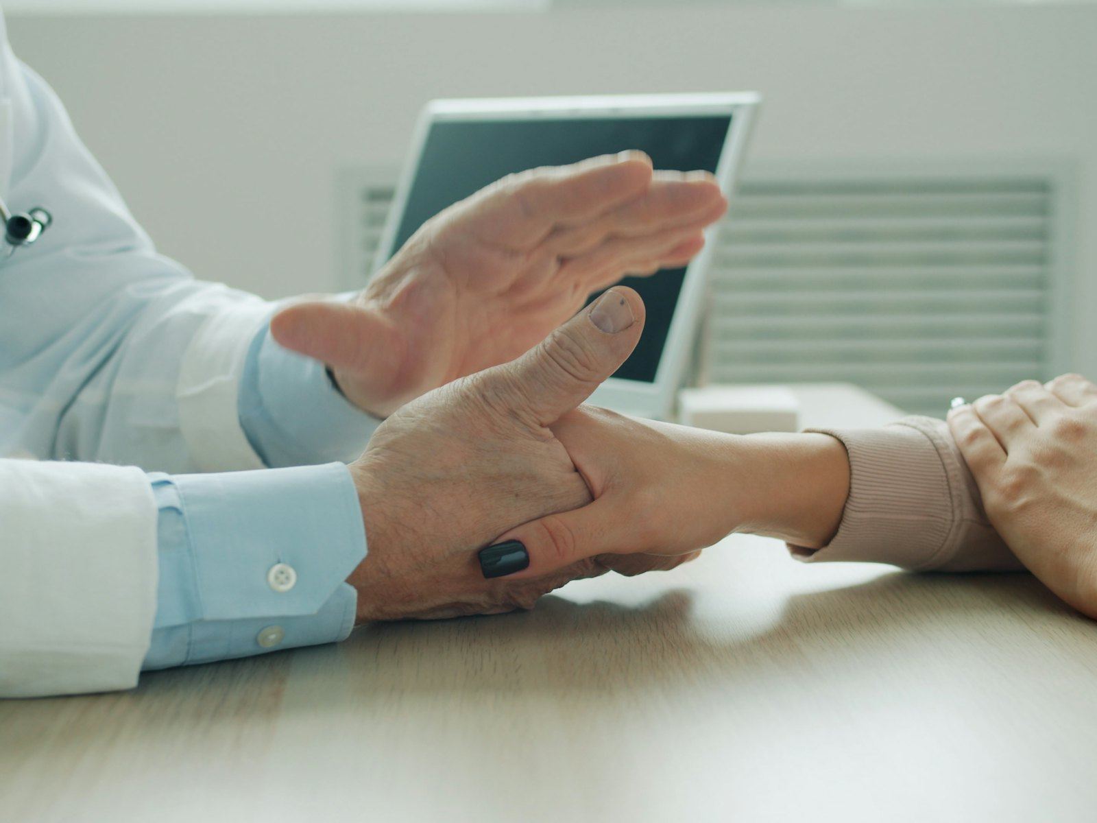 Doctor placing a comforting hand on a patient's arm.