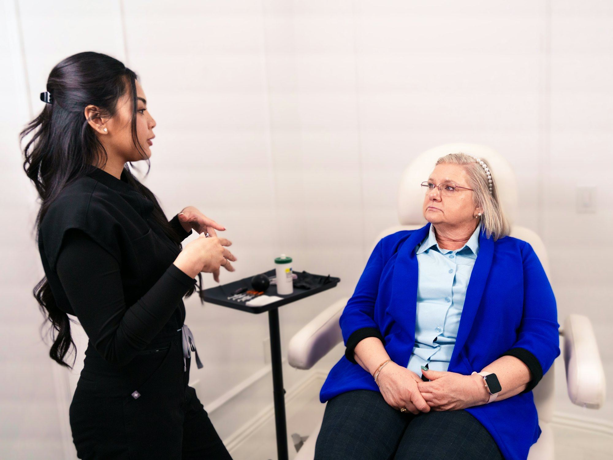 Professional consulting with a seated client in a clinic room.